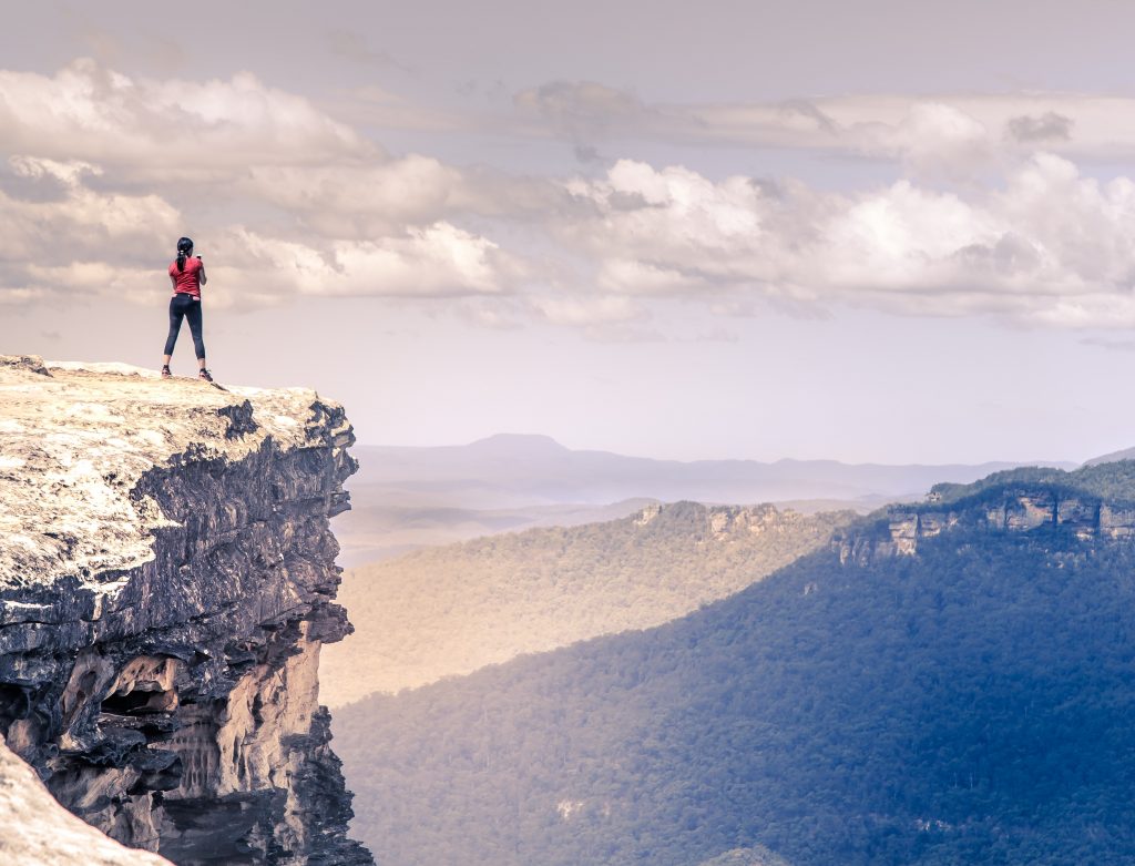 A picture of a person stood at the edge of a cliff