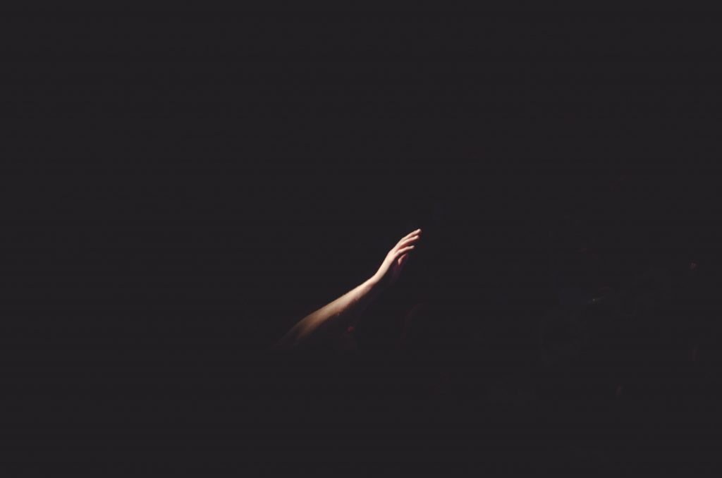 A picture of a reaching hand in darkness