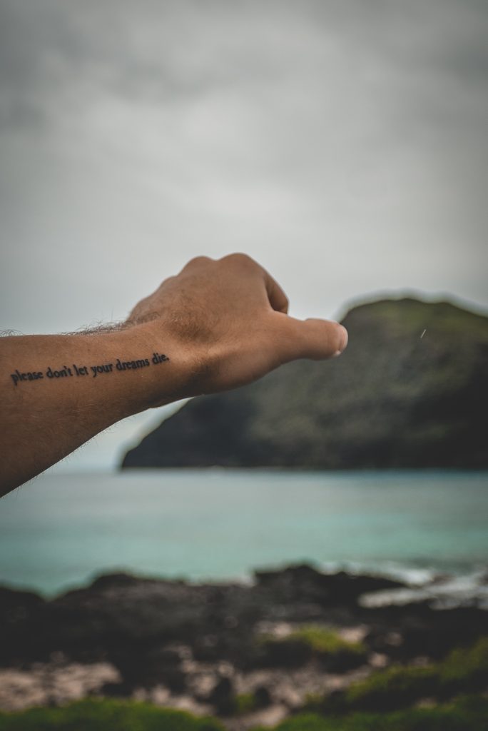 A picture of someone reaching out with a tattoo.