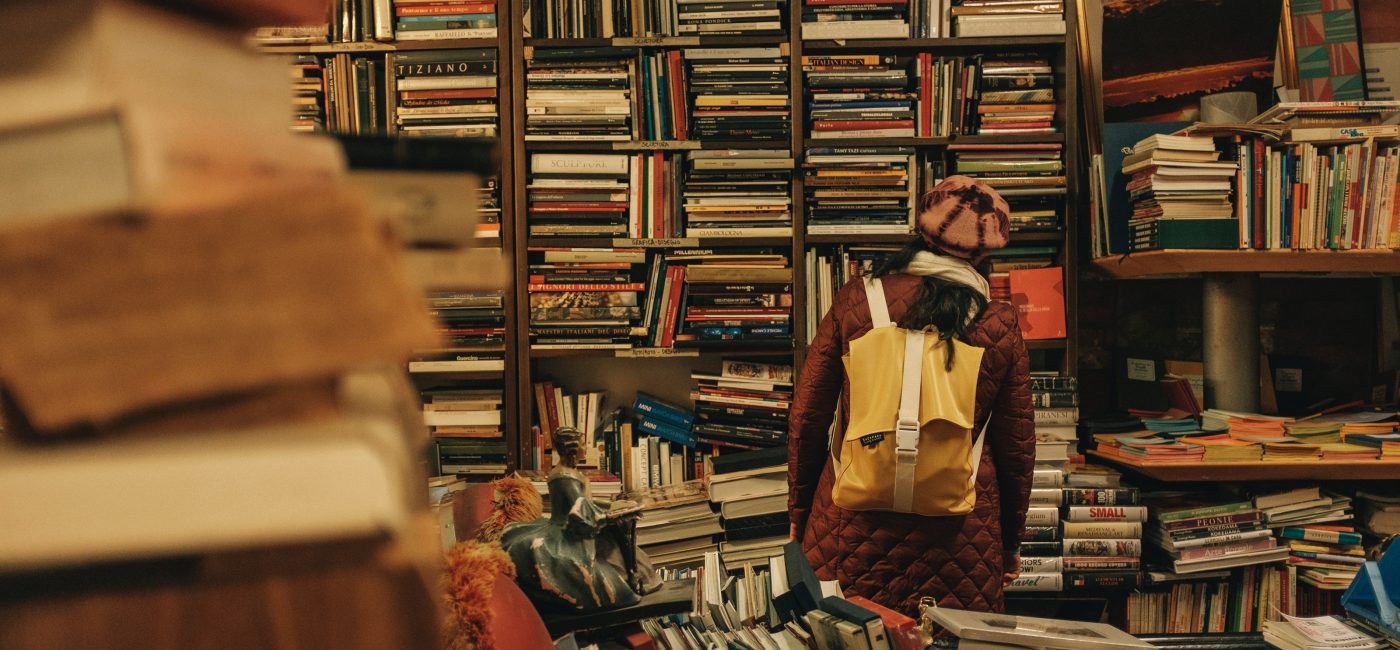 A picture of someone with their face in a bookshelf